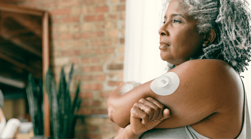 Ultrahuman smart ring on hand alongside a fitness tracker